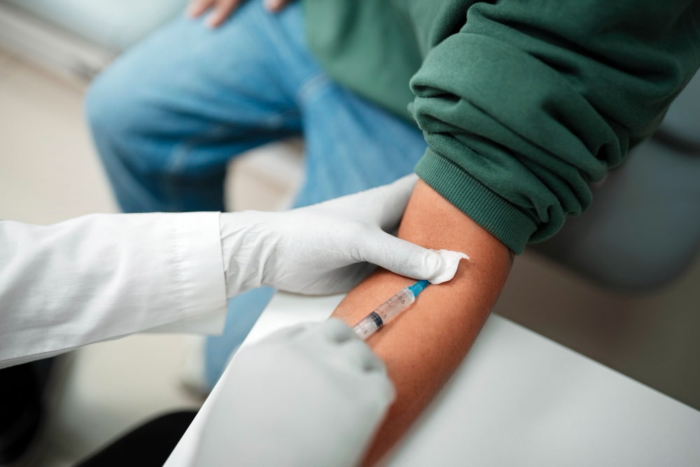 A medical professional safely administering an IV injection to a patient’s arm in a clinical setting, highlighting professional IV therapy services Delaware.