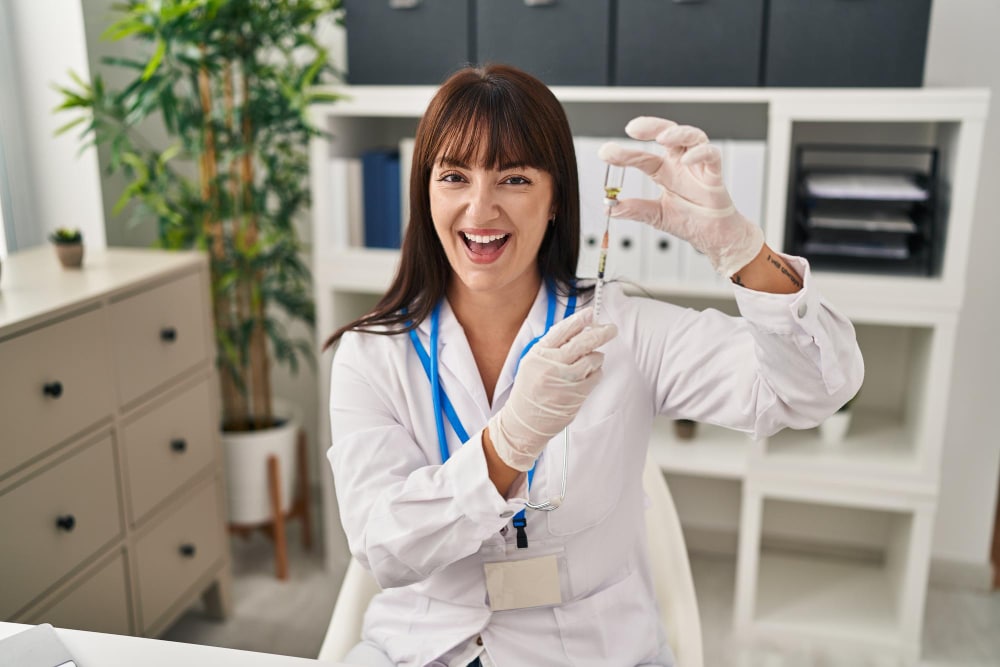 A smiling healthcare professional prepares a syringe in a clean clinic setting, highlighting infusion care planning dover delaware with expert, compassionate care.