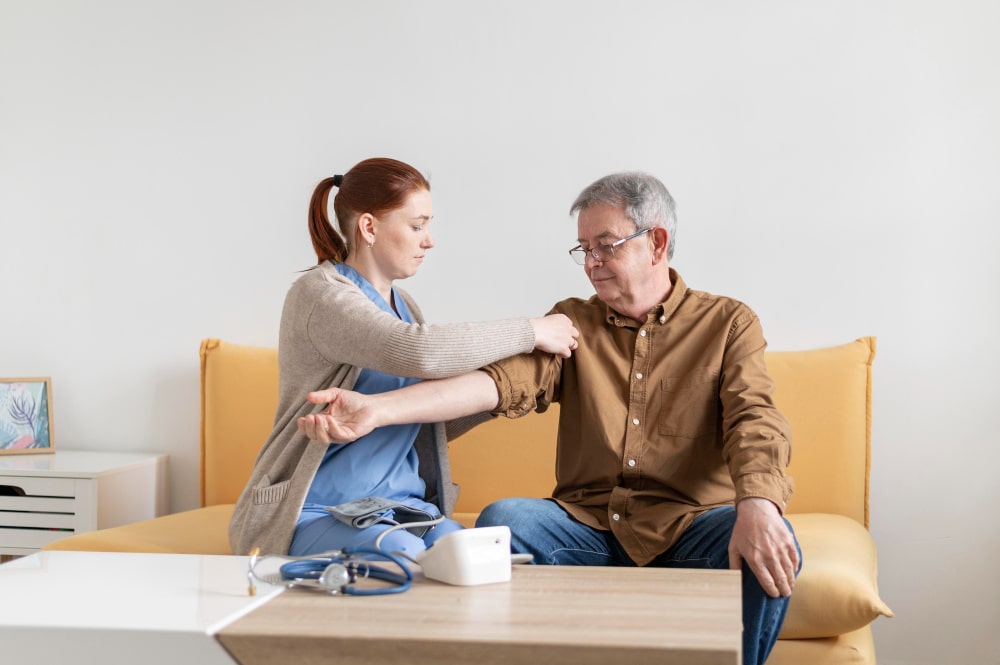 Nurse checking senior man’s blood pressure at home, Geriatric Care Dover Delaware.
